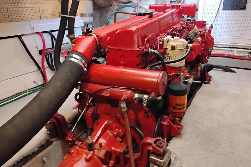 Slide: The Image of Engine room of a 1978 Puget 38 Europa Trawler with red machinery and hoses. - 62