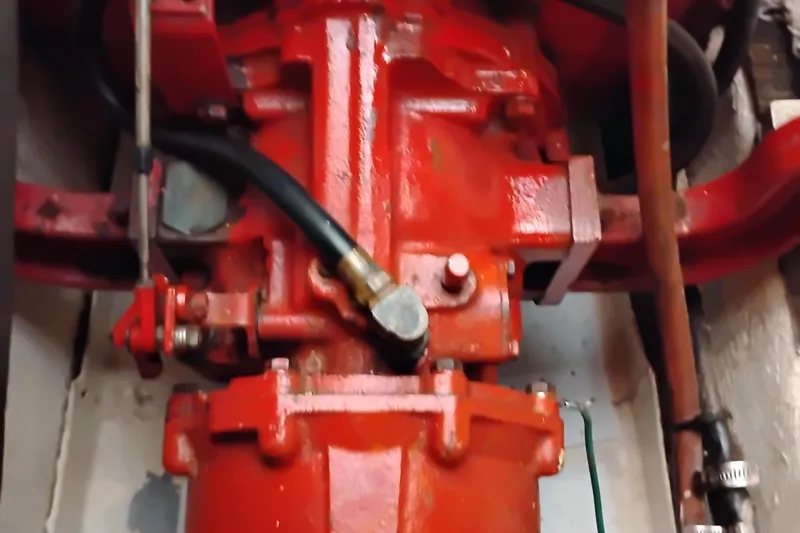 Slide: The Image of Engine component of 1978 Puget 38 Europa Trawler, featuring red mechanical parts and hoses. - 64