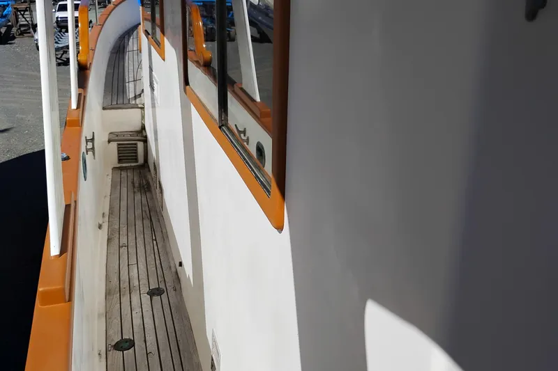 Slide: The Image of 1978 Puget 38 Europa Trawler side deck with wooden flooring and orange trim. - 7