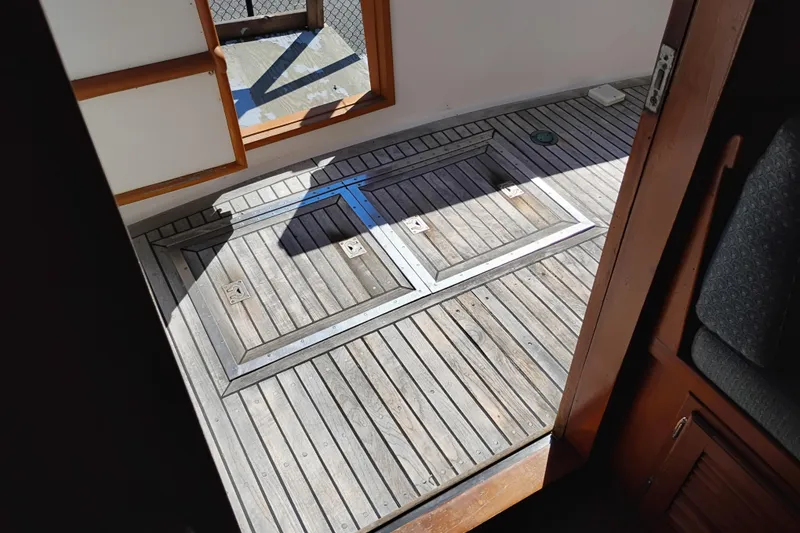 Slide: The Image of Wooden deck of 1978 Puget 38 Europa Trawler, featuring hatch doors and sunlight. - 8