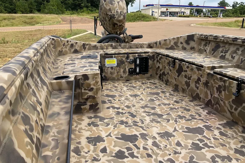 Slide: The Image of 2026 Excel 1751 Viper Duck Boat with camouflage interior, parked outdoors. - 4