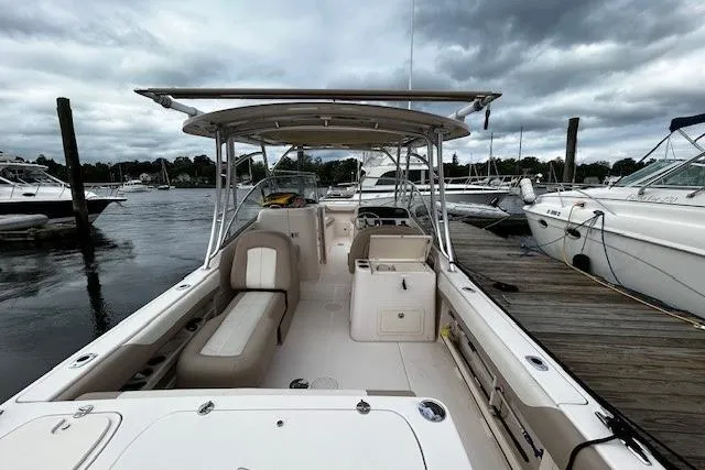 Slide: The Image of 2013 Grady-White Freedom 285 boat docked, showcasing spacious seating and sleek design. - 10