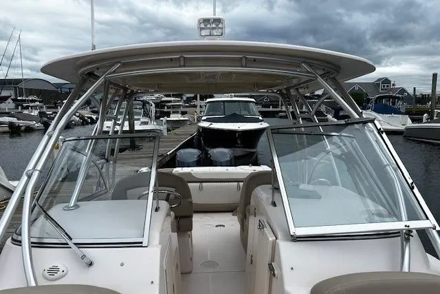 Slide: The Image of 2013 Grady-White Freedom 285 boat docked at marina under cloudy sky. - 3