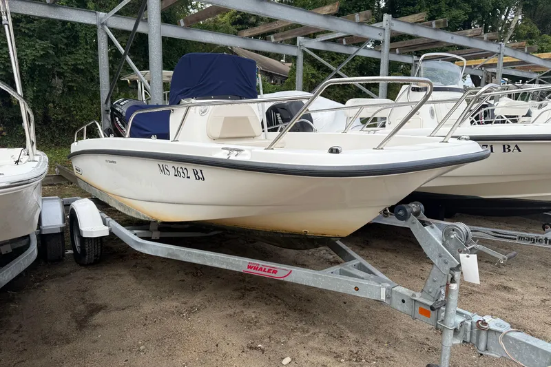 Slide: The Image of 2017 Boston Whaler 170 Dauntless boat on trailer, parked outdoors. - 0