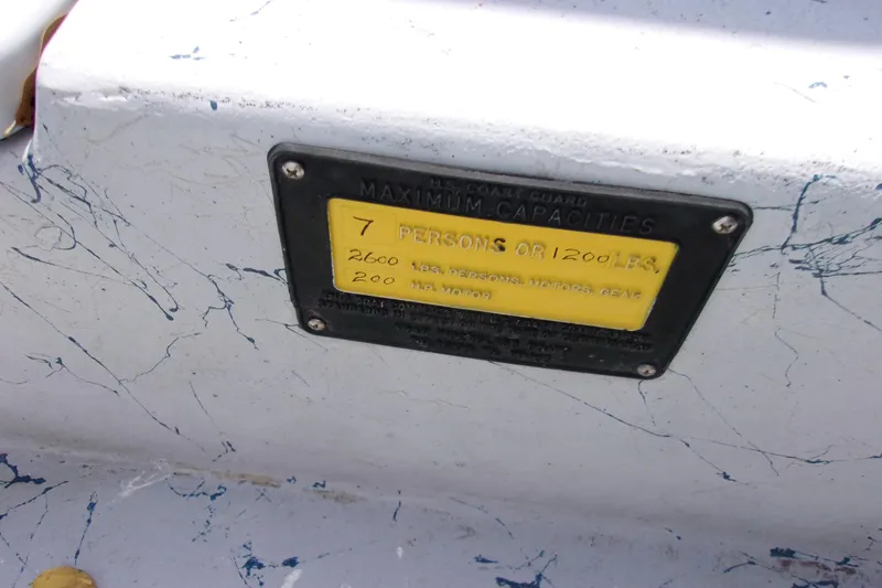 Slide: The Image of Boat capacity plate showing limits: 7 persons or 1200 lbs, Tran Cat 21, 2004 model. - 13