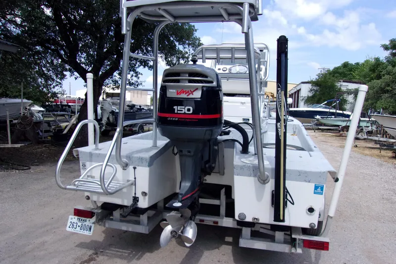 Slide: The Image of 2004 Tran Cat 21 boat with Yamaha VMAX 150 outboard motor, parked outdoors. - 3