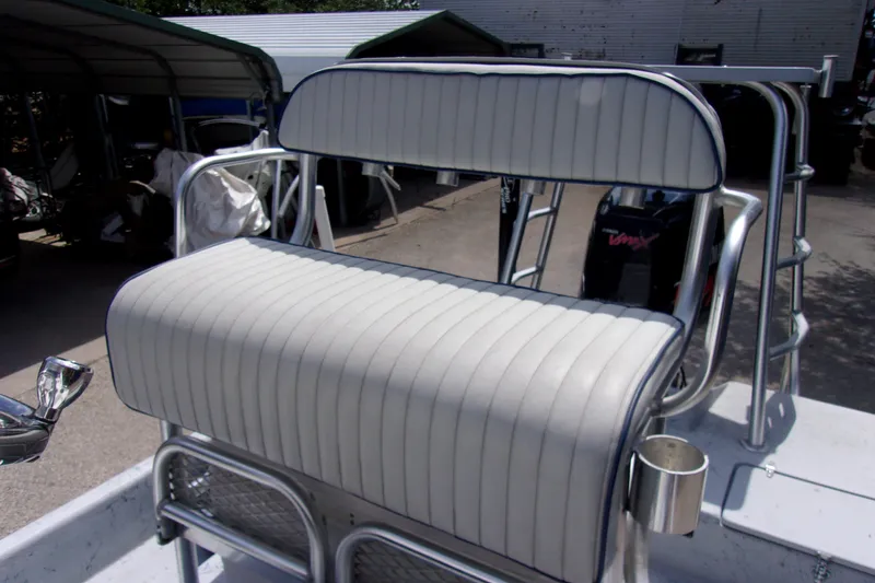Slide: The Image of White cushioned boat seat on a 2004 Tran Cat 21, with metal frame and cup holder. - 5