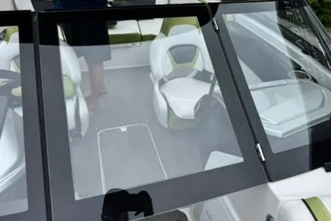 Slide: The Image of 2015 Scarab 195 boat interior with green and white seating, viewed through windshield. - 14