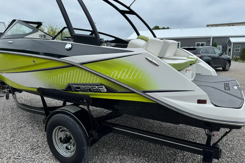 Slide: The Image of 2015 Scarab 195 boat with vibrant green accents on a trailer. - 5