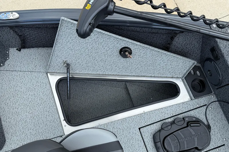 Slide: The Image of 2026 Lund 1775 Impact XS Sport boat interior with storage compartment and Minn Kota trolling motor. - 13