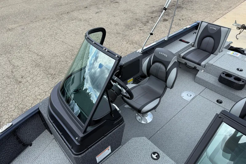 Slide: The Image of 2026 Lund 1775 Impact XS Sport boat interior with gray seating and steering console. - 15