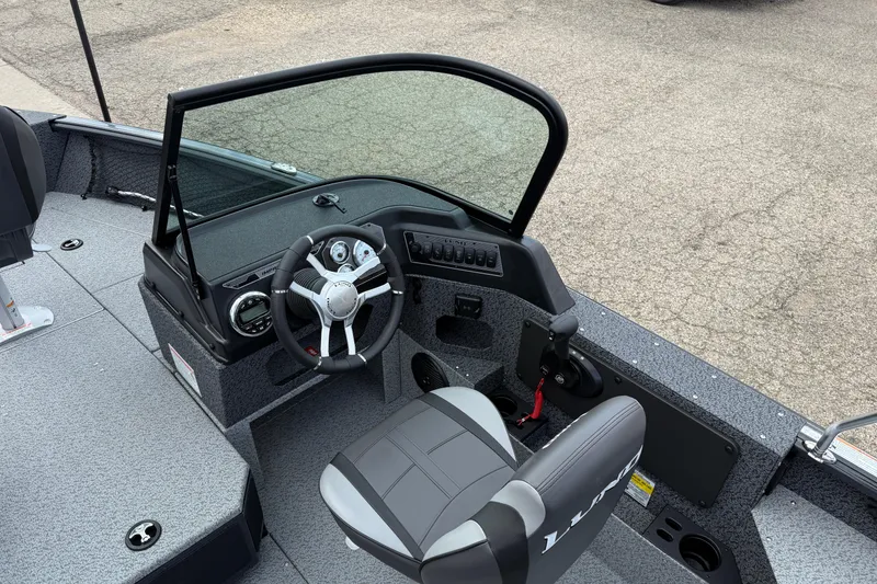 Slide: The Image of 2026 Lund 1775 Impact XS Sport boat interior with steering wheel and seating. - 17