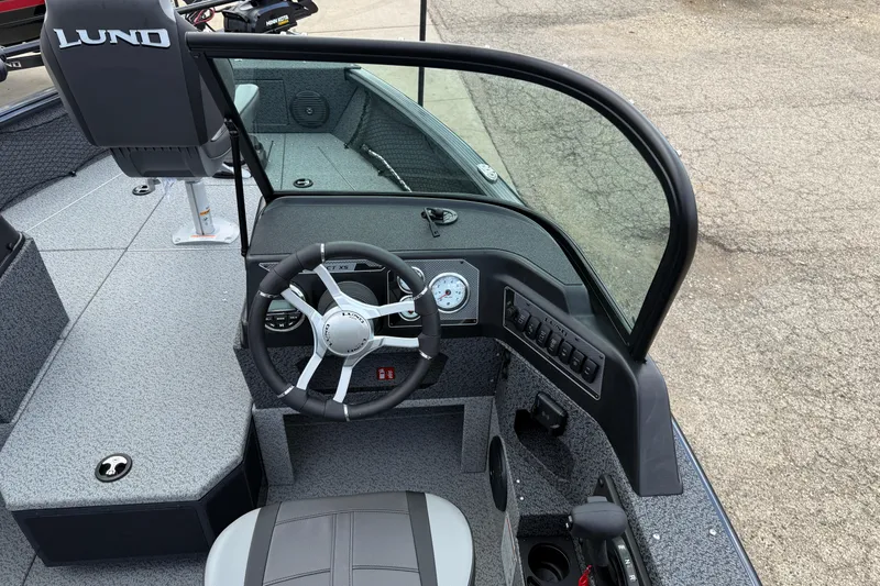 Slide: The Image of 2026 Lund 1775 Impact XS Sport boat interior with steering wheel and dashboard controls. - 18