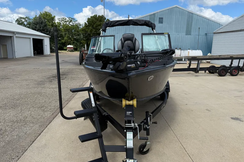 Slide: The Image of 2026 Lund 1775 Impact XS Sport boat on trailer, parked outdoors. - 2