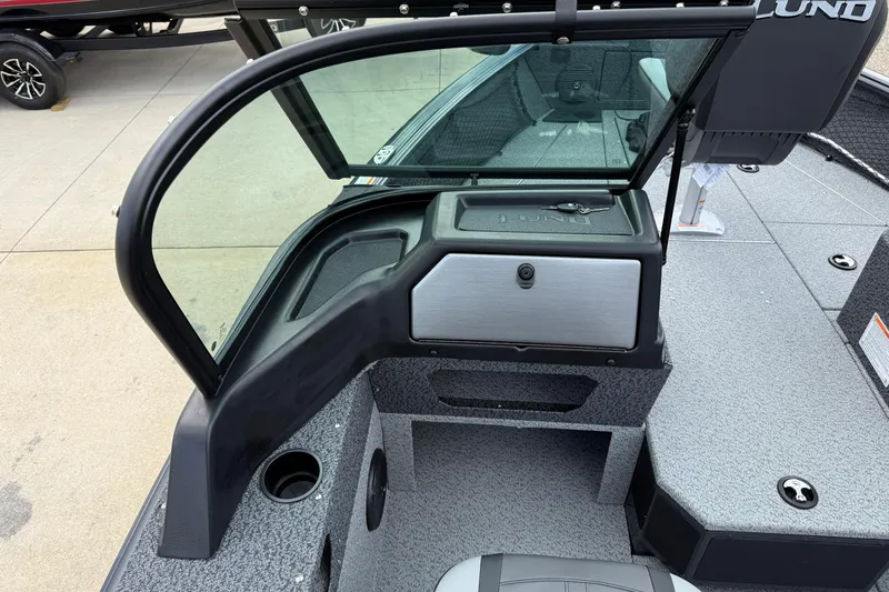 Slide: The Image of 2026 Lund 1775 Impact XS Sport boat interior with windshield and storage compartment. - 20