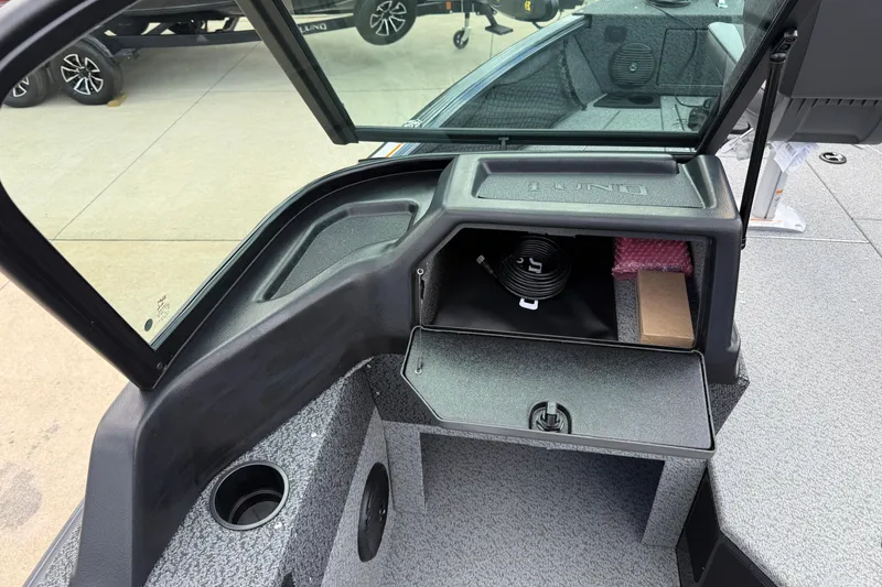 Slide: The Image of 2026 Lund 1775 Impact XS Sport boat interior with open storage compartment and windshield. - 21