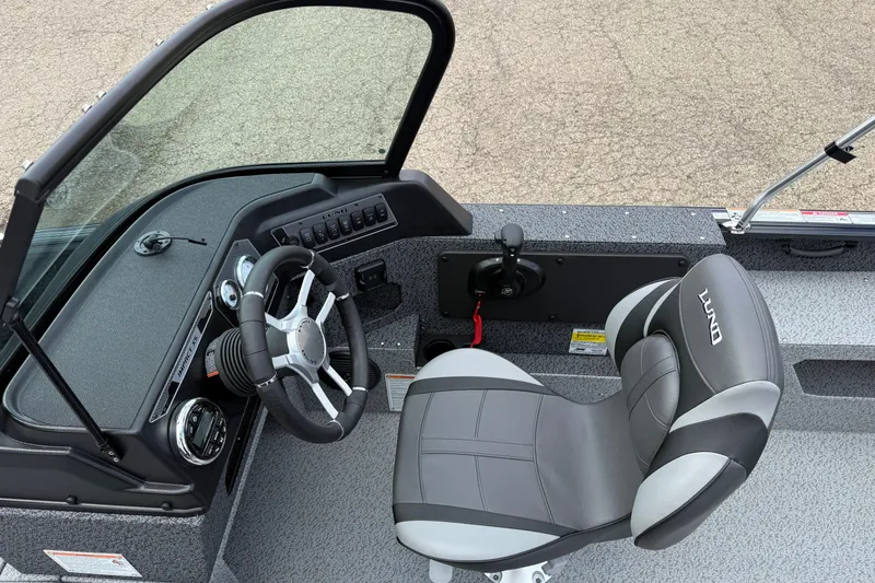 Slide: The Image of 2026 Lund 1775 Impact XS Sport boat interior with steering wheel and seat. - 23