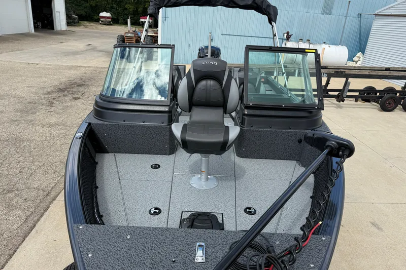 Slide: The Image of 2026 Lund 1775 Impact XS Sport boat with dual windshields and seating, parked outdoors. - 9