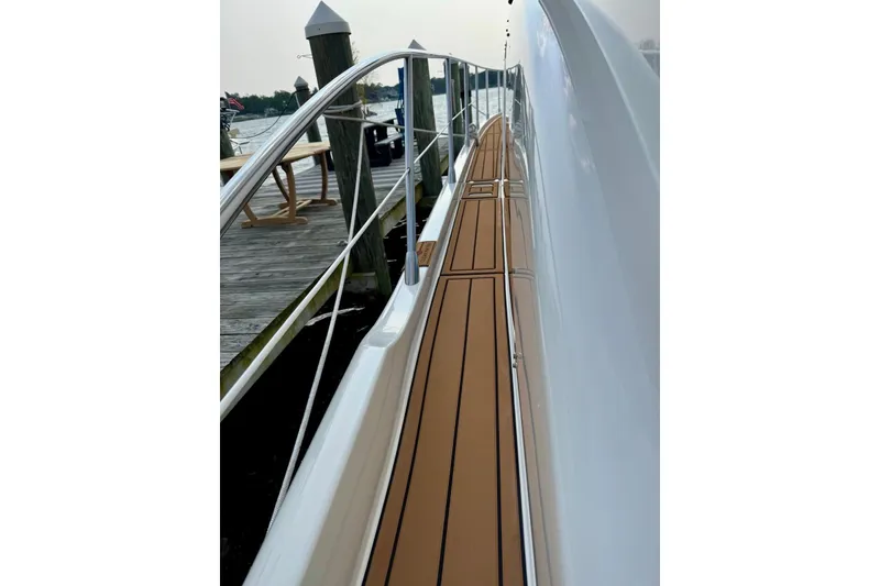 Slide: The Image of 2008 Azimut 55 Fly yacht deck with sleek wooden finish, docked at marina. - 21