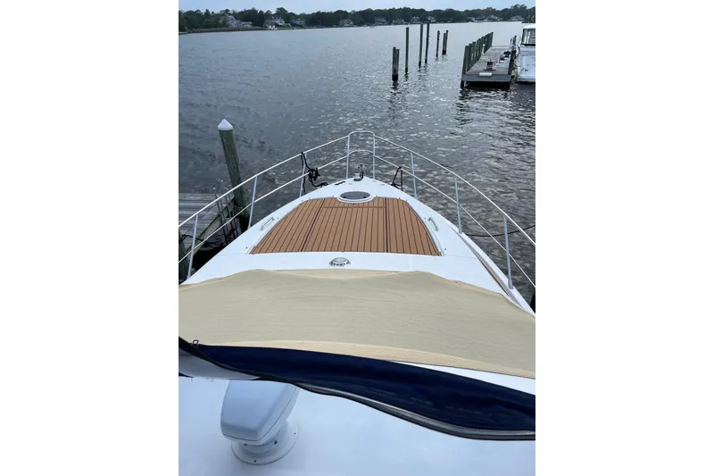 Slide: The Image of 2008 Azimut 55 Fly yacht bow view with wooden deck, docked by calm waters. - 25