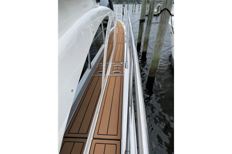 Slide: The Image of 2008 Azimut 55 Fly yacht deck with sleek wood finish and stainless steel railings. - 27
