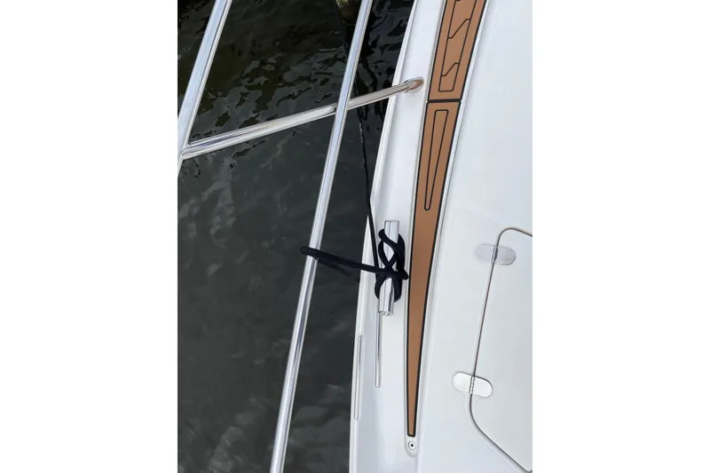 Slide: The Image of 2008 Azimut 55 Fly yacht deck with railing and cleat, docked by water. - 28