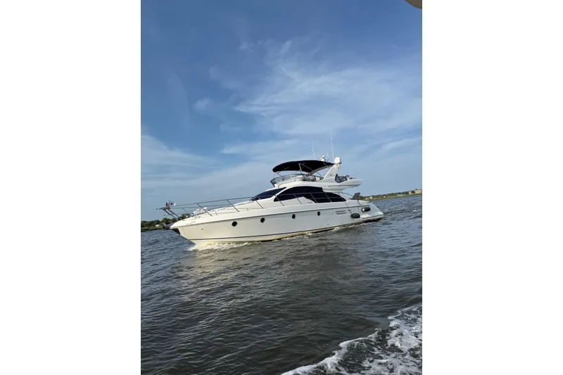 Slide: The Image of 2008 Azimut 55 Fly yacht cruising on open water under a clear blue sky. - 5