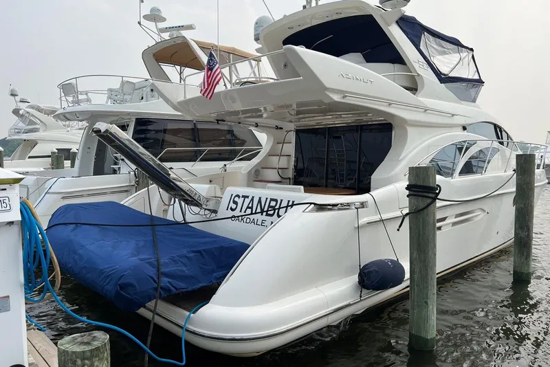 Slide: The Image of 2008 Azimut 55 Fly yacht docked, featuring sleek design and American flag. - 76