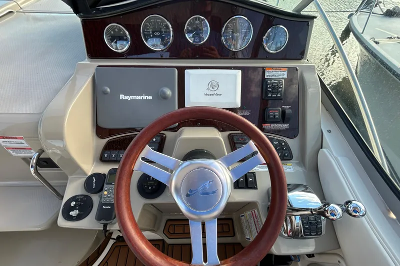 Slide: The Image of Cockpit of 2010 Sea Ray Sundancer 330 with Raymarine navigation system and wood-accented steering wheel. - 12