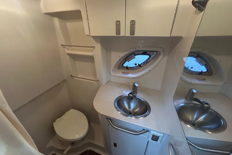 Slide: The Image of 2010 Sea Ray Sundancer 330 bathroom with sink, toilet, and porthole window. - 20