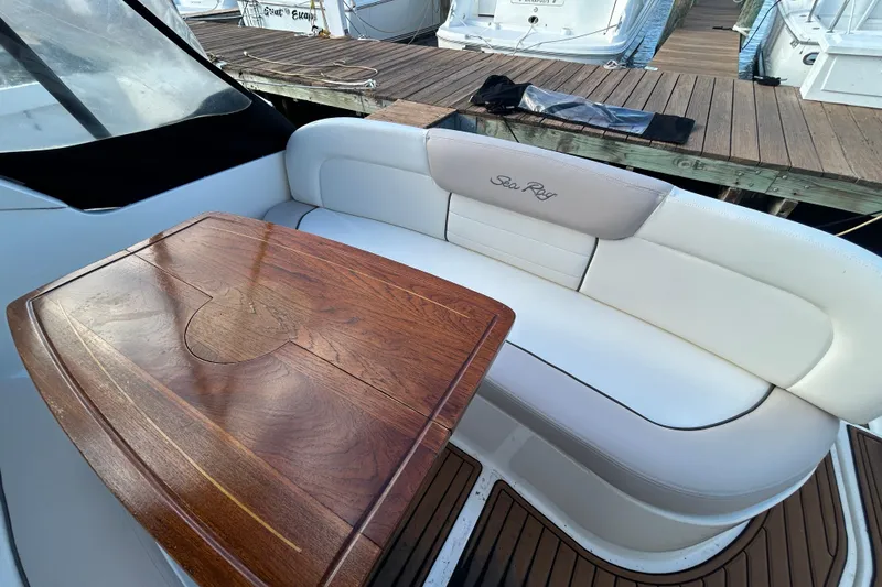 Slide: The Image of Sea Ray Sundancer 330, 2010 model, featuring elegant seating and a wooden table on deck. - 6