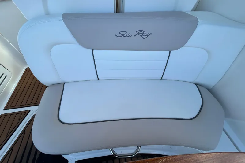 Slide: The Image of 2010 Sea Ray Sundancer 330 boat seat with logo, featuring white and beige upholstery. - 8