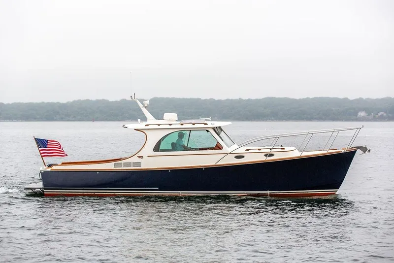 Slide: The Image of 2010 Hinckley Picnic Boat MKIII cruising on calm waters with American flag. - 2
