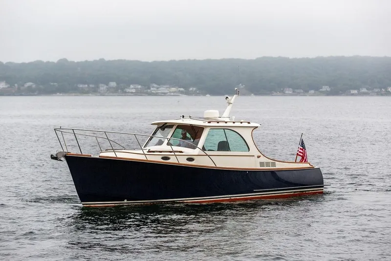 Slide: The Image of Hinckley Picnic Boat MKIII 2010 cruising on calm waters with American flag. - 5