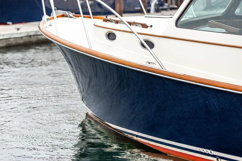 Slide: The Image of 2010 Hinckley Picnic Boat MKIII with sleek navy hull and wooden trim in marina. - 6