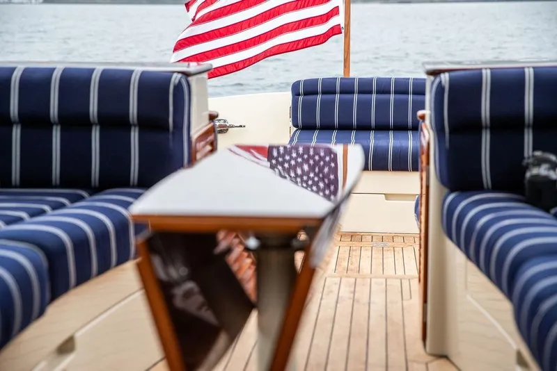 Slide: The Image of Hinckley Picnic Boat MKIII 2010 with striped seating and American flag on deck. - 10