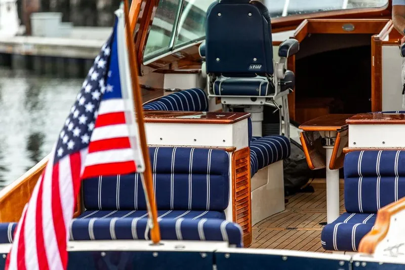 Slide: The Image of Hinckley Picnic Boat MKIII 2010 interior with striped seating and American flag. - 11