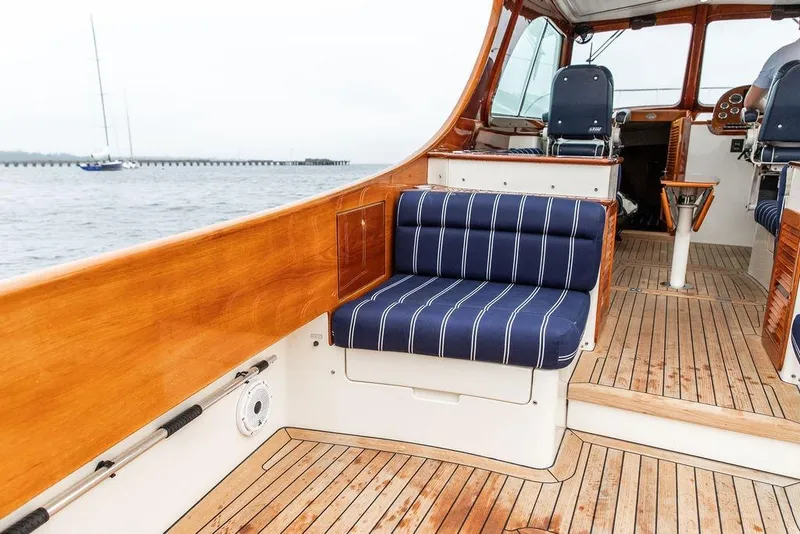 Slide: The Image of Hinckley Picnic Boat MKIII 2010 interior with wooden deck and striped seating. - 12