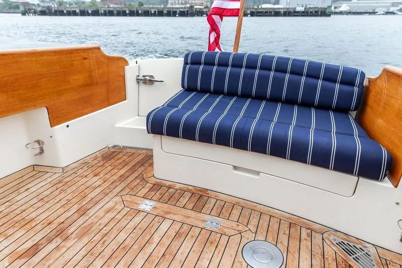 Slide: The Image of Hinckley Picnic Boat MKIII 2010 with striped seating and wooden deck, dockside view. - 14