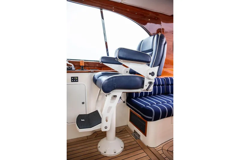 Slide: The Image of Captain's chair on 2010 Hinckley Picnic Boat MKIII, featuring blue upholstery and wooden interior. - 19