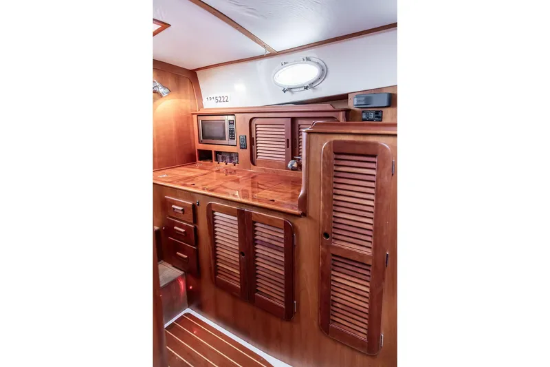 Slide: The Image of Hinckley Picnic Boat MKIII 2010 interior with wooden cabinetry and built-in microwave. - 21