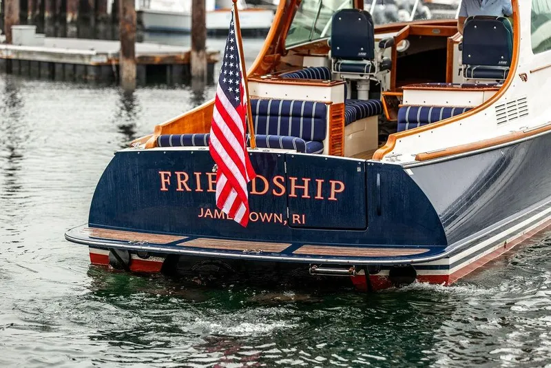 Slide: The Image of Hinckley Picnic Boat MKIII 2010, named "Friendship," with American flag, docked in Jamestown, RI. - 7