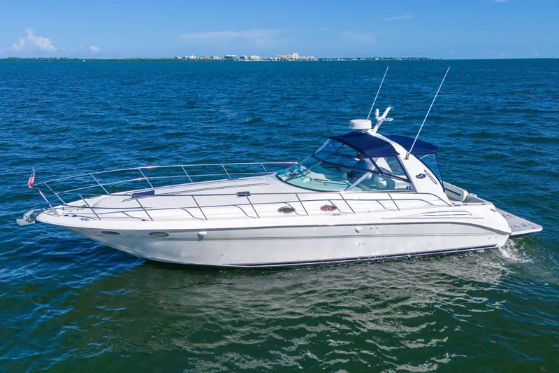 Slide: The Image of 1997 Sea Ray 400 Sundancer yacht cruising on open water under clear blue skies. - 13