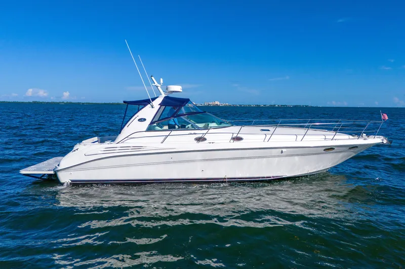 Slide: The Image of 1997 Sea Ray 400 Sundancer yacht cruising on open water under clear blue skies. - 7