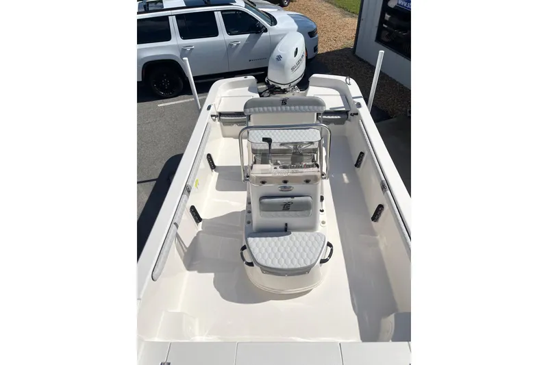 Slide: The Image of 2026 Carolina Skiff 19 LS boat interior with seating and console, parked outdoors. - 11