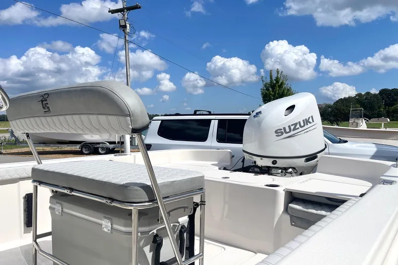Slide: The Image of 2026 Carolina Skiff 19 LS boat with Suzuki outboard motor, parked under a clear blue sky. - 26