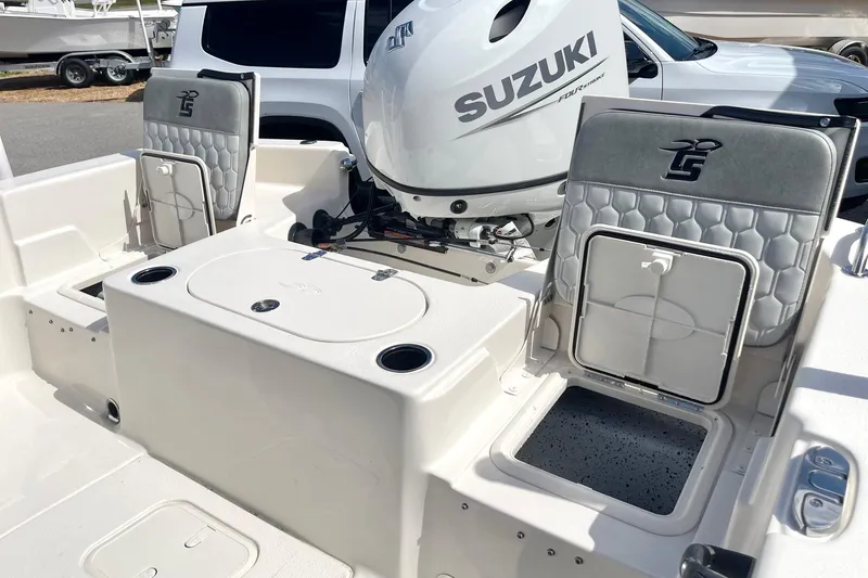 Slide: The Image of 2026 Carolina Skiff 19 LS boat interior with Suzuki engine, featuring seating and storage compartments. - 29
