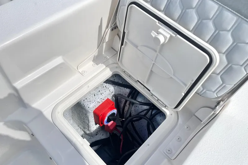 Slide: The Image of 2026 Carolina Skiff 19 LS boat storage compartment with wiring and red switch. - 30