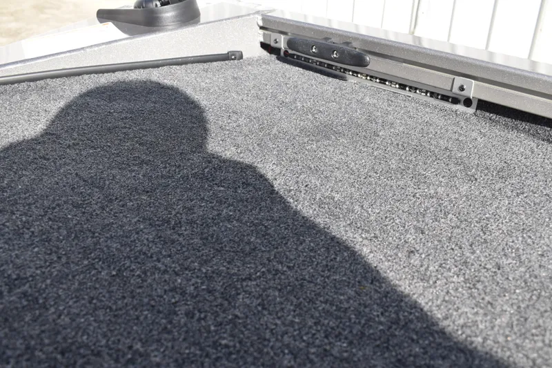 Slide: The Image of 2026 Lowe Stinger 175C boat storage compartment with yellow lid and carpeted interior. - 40