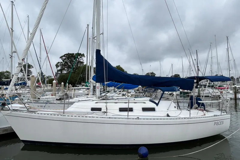 Slide: The Image of 1988 J Boats J/28 sailboat docked in a marina under cloudy skies. - 1